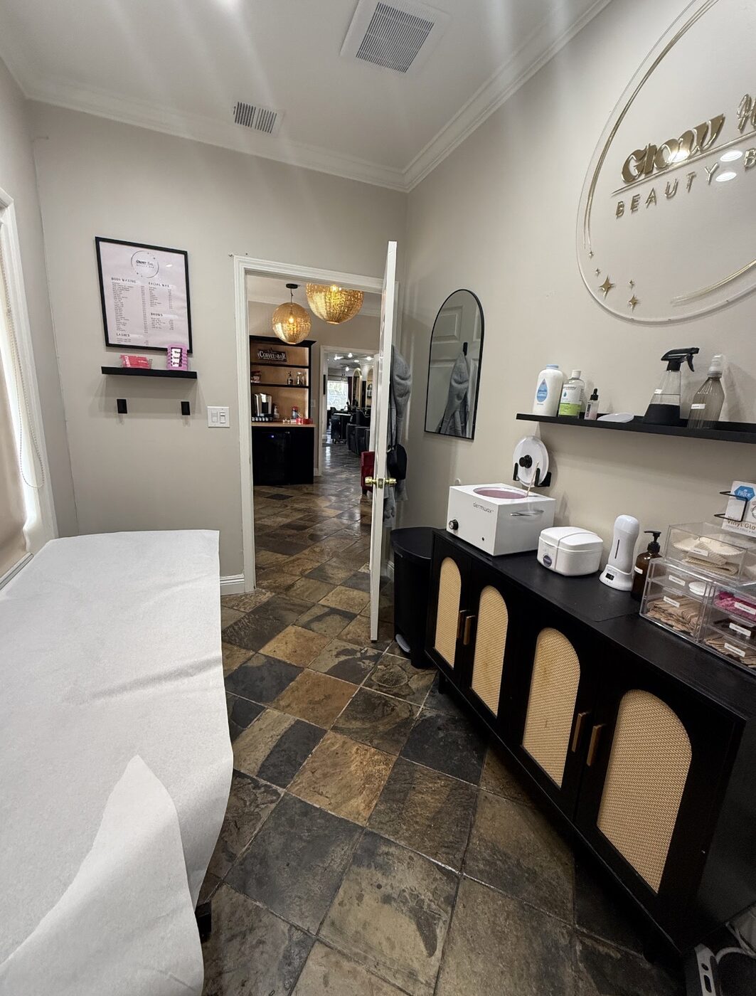 The waxing room at Glow Haus Beauty Bar with the gold Glow Haus sign